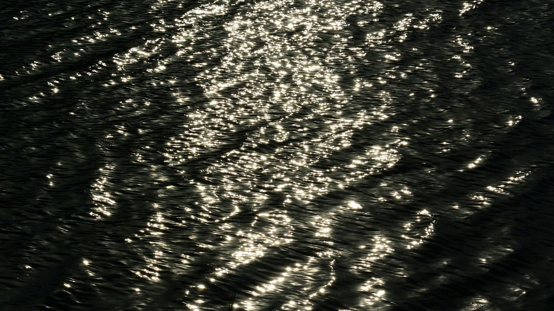 A serene person practicing a fluid yoga movement in a calm, dark environment.